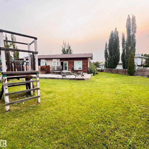 Expansive level grounds featuring mature poplar trees and lush manicured lawn - 4821 11A Avenue Nw, Edmonton, AB - Outdoor With Deck Patio Veranda