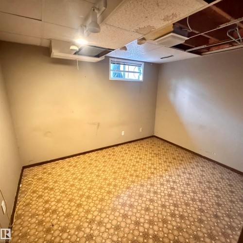 Finished basement room featuring polished concrete flooring with geometric patterning, recessed ceiling lighting, and fresh drywall - 4821 11A Avenue Nw, Edmonton, AB - Indoor Photo Showing Basement