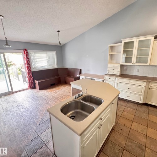 Kitchen island featuring a dual stainless steel sink - 4821 11A Avenue Nw, Edmonton, AB - Indoor Photo Showing Kitchen With Double Sink