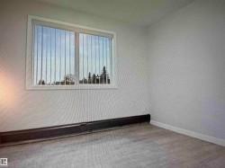 Recessed window with vertical blinds, light gray wall paint, and wood-finish flooring - 