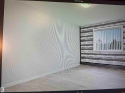 Wall-mounted light fixture, window with horizontal blinds, and a textured accent wall - 
