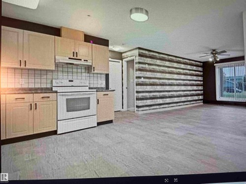 Open-concept kitchen and living area featuring light wood-finish cabinetry, white tile backsplash, a built-in electric range, and light-toned flooring - #106 592 Hooke Rd Nw, Edmonton, AB 