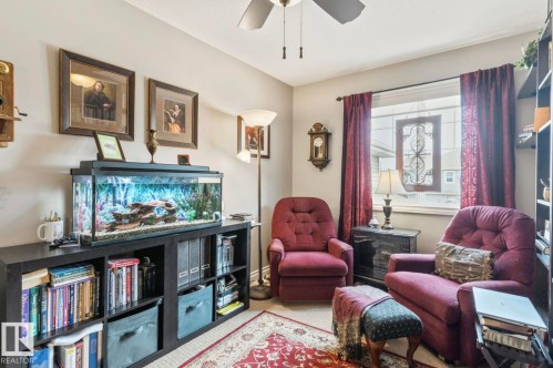 Warmly appointed room featuring a ceiling fan, a window with decorative leaded glass, and built-in shelving - 22 Voleta Crest, Spruce Grove, AB - Indoor
