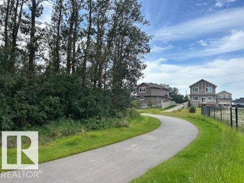 Paved pathway bordered by manicured grass and mature trees - 247 Edgemont Green Green Nw, Edmonton, AB 