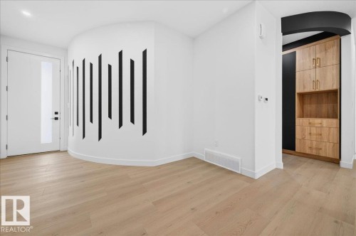 Modern entryway featuring wood-finish flooring and a curved accent wall - 403 172 Avenue Nw, Edmonton, AB - Indoor Photo Showing Other Room