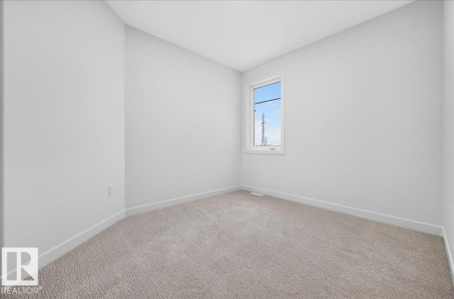 Bright room featuring a single window, light-toned carpeting, white walls, and white trim - 403 172 Avenue Nw, Edmonton, AB - Indoor Photo Showing Other Room