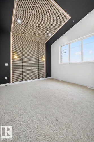 Room featuring a decorative slatted wood accent wall and ceiling with integrated recessed lighting - 403 172 Avenue Nw, Edmonton, AB - Indoor Photo Showing Other Room