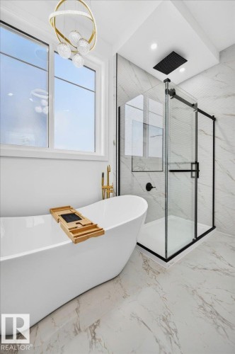 Freestanding soaking tub with gold-tone fixtures - 403 172 Avenue Nw, Edmonton, AB - Indoor Photo Showing Bathroom