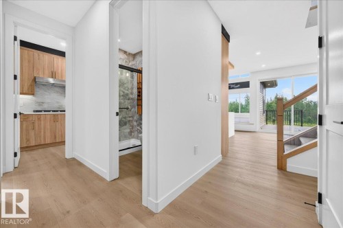 Hardwood-style flooring throughout the main level - 403 172 Avenue Nw, Edmonton, AB - Indoor Photo Showing Other Room