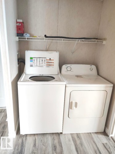 Dedicated laundry area with wood-finish flooring - 4819 51 Avenue, Millet, AB - Indoor Photo Showing Laundry Room