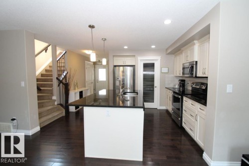 Kitchen featuring a large island with a dark countertop and pendant lighting - 3048 Harvey Crescent Nw, Edmonton, AB - Indoor Photo Showing Kitchen With Upgraded Kitchen
