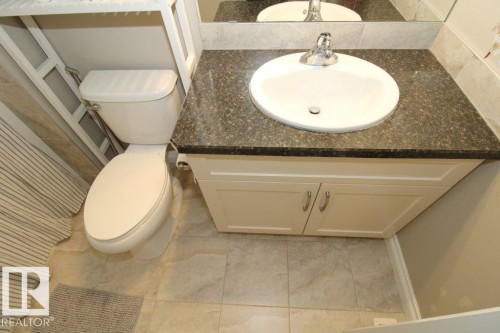 White vanity with a speckled countertop, undermount sink, and chrome faucet - 3048 Harvey Crescent Nw, Edmonton, AB - Indoor Photo Showing Bathroom