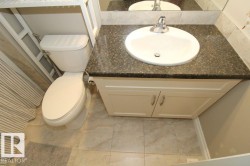 White vanity with a speckled countertop, undermount sink, and chrome faucet - 
