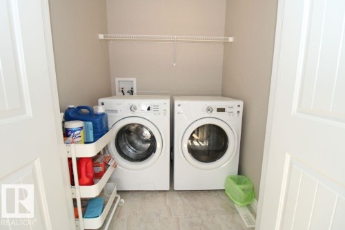 Dedicated laundry area featuring tile flooring, neutral wall paint, and a white wire shelf - 3048 Harvey Crescent Nw, Edmonton, AB - Indoor Photo Showing Laundry Room