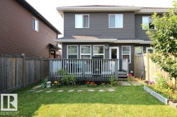Rear exterior featuring a spacious deck with perimeter railing and steps to the lawn - 