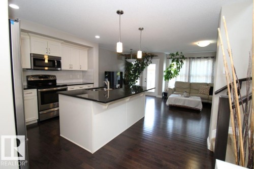 Open-concept living space featuring rich wood-finish flooring - 3048 Harvey Crescent Nw, Edmonton, AB - Indoor Photo Showing Kitchen With Upgraded Kitchen
