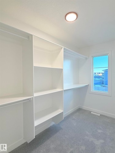 Built-in white shelving and hanging rods providing ample storage - 3150 Magpie Way Nw, Edmonton, AB - Indoor With Storage