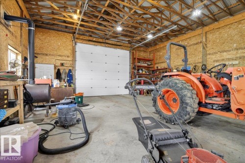 Spacious workshop with high ceilings, exposed beam structure, and ample natural lighting - 531064 Range Road 174, Rural Lamont County, AB - Indoor Photo Showing Garage