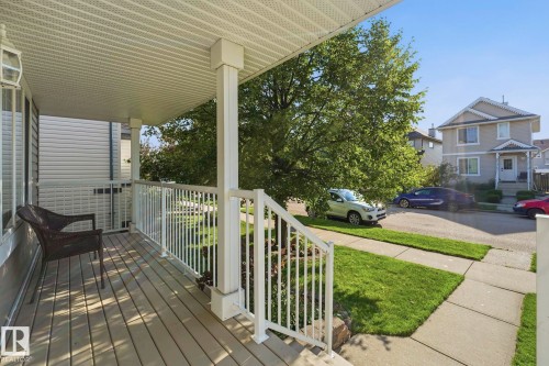 Covered front porch featuring composite decking and white railings - 215 85 Street Sw, Edmonton, AB 