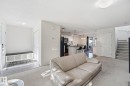 Open-concept living space featuring neutral carpet flooring, a light-filled interior with recessed ceiling lighting, and seamless sightlines to the kitchen area - 215 85 Street Sw, Edmonton, AB  - Indoor Photo Showing Living Room 