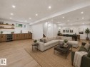 Spacious entertainment area featuring wood-finish flooring, recessed lighting, and a built-in wet bar with a beverage refrigerator - 3318 Chickadee Drive Nw, Edmonton, AB  - Indoor Photo Showing Living Room 