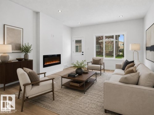 Living area featuring light wood-finish flooring, recessed lighting, and a modern wall-mounted fireplace - 3318 Chickadee Drive Nw, Edmonton, AB - Indoor Photo Showing Living Room With Fireplace
