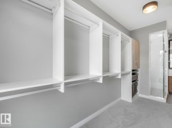 Custom closet system featuring white shelving and hanging rods - 