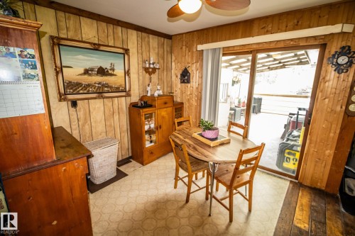 Dining area featuring wood-paneled walls and a ceiling fan - 11218 Twp Rd 590, Rural St. Paul County, AB - Indoor Photo Showing Dining Room