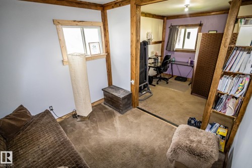 Carpeted interior space featuring exposed wood beams and light-toned wall finishes - 11218 Twp Rd 590, Rural St. Paul County, AB - Indoor