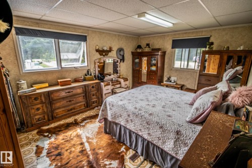 Charming interior space featuring wall-to-wall carpeting and neutral-toned wallpaper - 11218 Twp Rd 590, Rural St. Paul County, AB - Indoor Photo Showing Bedroom