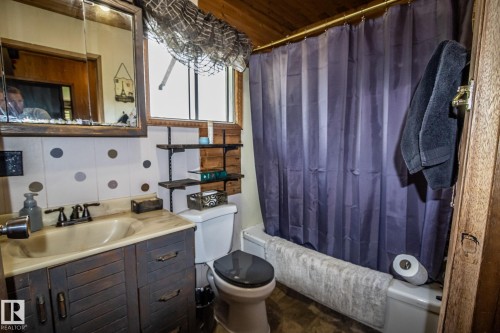 Bathroom featuring a shower-tub combination, a vanity with integrated sink, and a framed medicine cabinet - 11218 Twp Rd 590, Rural St. Paul County, AB - Indoor Photo Showing Bathroom