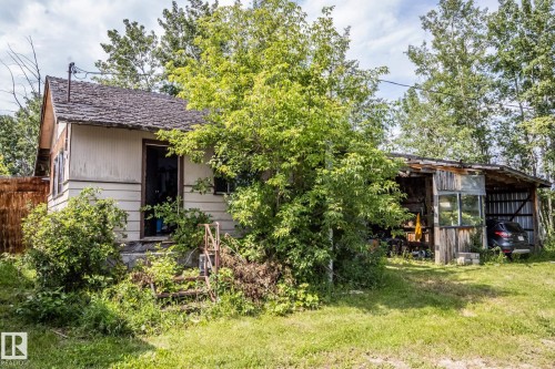 Exterior features include horizontal siding, a gabled roofline, and mature trees providing natural screening - 11218 Twp Rd 590, Rural St. Paul County, AB - Outdoor