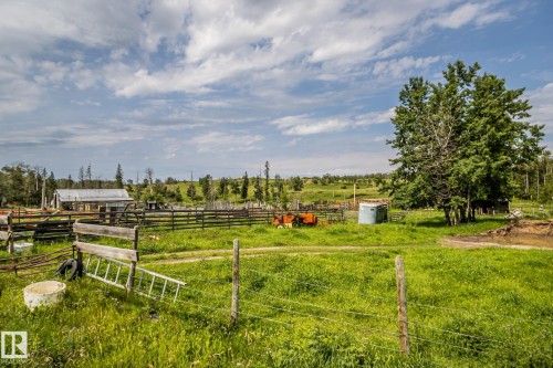 Expansive rural property featuring a large field, mature trees, and a distant outbuilding - 11218 Twp Rd 590, Rural St. Paul County, AB - Outdoor With View