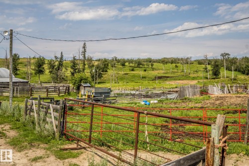 Expansive rural property featuring multiple functional outbuildings, sturdy post-and-rail fencing, and open pastureland with scattered mature tree coverage - 11218 Twp Rd 590, Rural St. Paul County, AB - Outdoor With View
