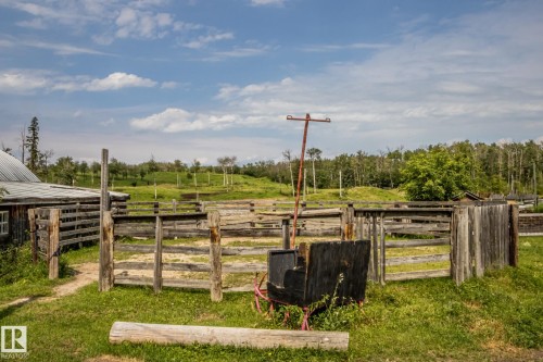 Rustic wooden fencing enclosing a green pasture area, featuring a metal-roofed outbuilding - 11218 Twp Rd 590, Rural St. Paul County, AB - Outdoor With View