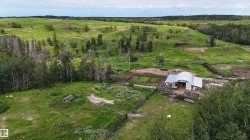 Expansive green landscape featuring a functional barn structure - 