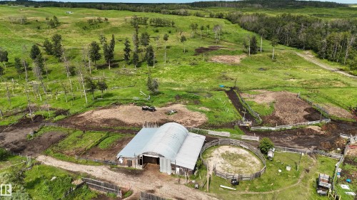 Agricultural property featuring a large barn, multiple fenced paddocks, and a round pen - 11218 Twp Rd 590, Rural St. Paul County, AB - Outdoor With View