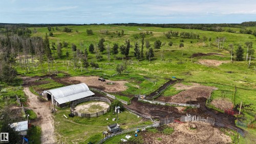Expansive acreage featuring a large barn with a corrugated metal roof, multiple fenced enclosures, and a circular pen - 11218 Twp Rd 590, Rural St. Paul County, AB - Outdoor With View