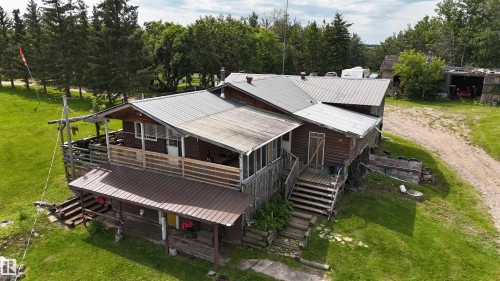 Charming residential property featuring a multi-section design with metal roofing, expansive composite decking, and covered entry porches - 11218 Twp Rd 590, Rural St. Paul County, AB - Outdoor