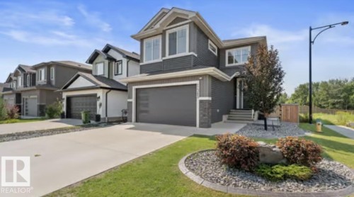 Modern two-story home featuring a striking contemporary exterior with mixed siding finishes, peaked roofline with gabled detailing, and multiple windows providing abundant natural light - 12383 176 Avenue Nw, Edmonton, AB - Outdoor With Facade