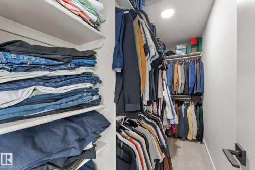 Walk-in closet featuring extensive built-in shelving, multiple hanging rods, recessed lighting, and soft gray carpeting - 12383 176 Avenue Nw, Edmonton, AB - Indoor With Storage