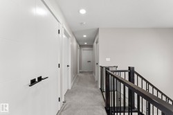 Upper-level hallway with neutral wall tones and recessed lighting - 