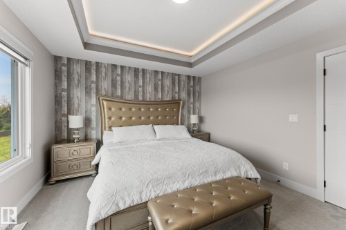 Tray ceiling with recessed lighting above a feature wall with wood-finish paneling - 12383 176 Avenue Nw, Edmonton, AB - Indoor Photo Showing Bedroom