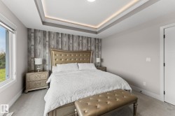 Tray ceiling with recessed lighting above a feature wall with wood-finish paneling - 