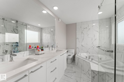 Bathroom featuring a dual vanity with undermount sinks, a corner soaking tub, and a separate glass-enclosed shower - 12383 176 Avenue Nw, Edmonton, AB - Indoor Photo Showing Bathroom