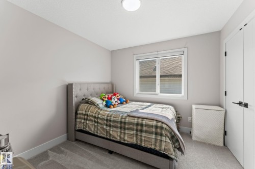 Bedroom featuring a window with a roller blind, light gray walls, white trim, and light gray carpet - 12383 176 Avenue Nw, Edmonton, AB - Indoor Photo Showing Bedroom