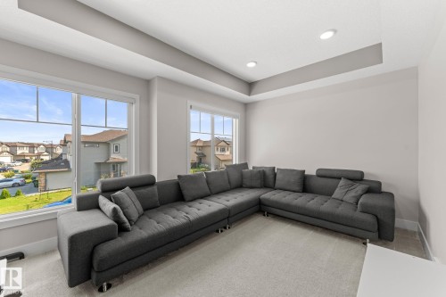 Spacious room featuring multiple large windows with white trim, a tray ceiling, recessed lighting, and light-colored wall paint - 12383 176 Avenue Nw, Edmonton, AB - Indoor Photo Showing Living Room