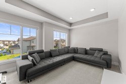 Spacious room featuring multiple large windows with white trim, a tray ceiling, recessed lighting, and light-colored wall paint - 