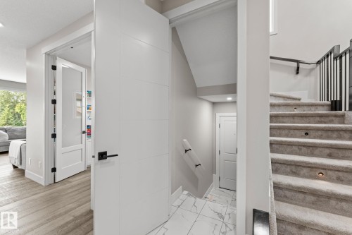 Carpeted staircase with integrated step lighting and black metal spindles - 12383 176 Avenue Nw, Edmonton, AB - Indoor Photo Showing Other Room