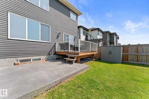 Fenced backyard featuring a concrete patio, wooden deck with white railing, and a storage shed - 12383 176 Avenue Nw, Edmonton, AB - Outdoor With Deck Patio Veranda